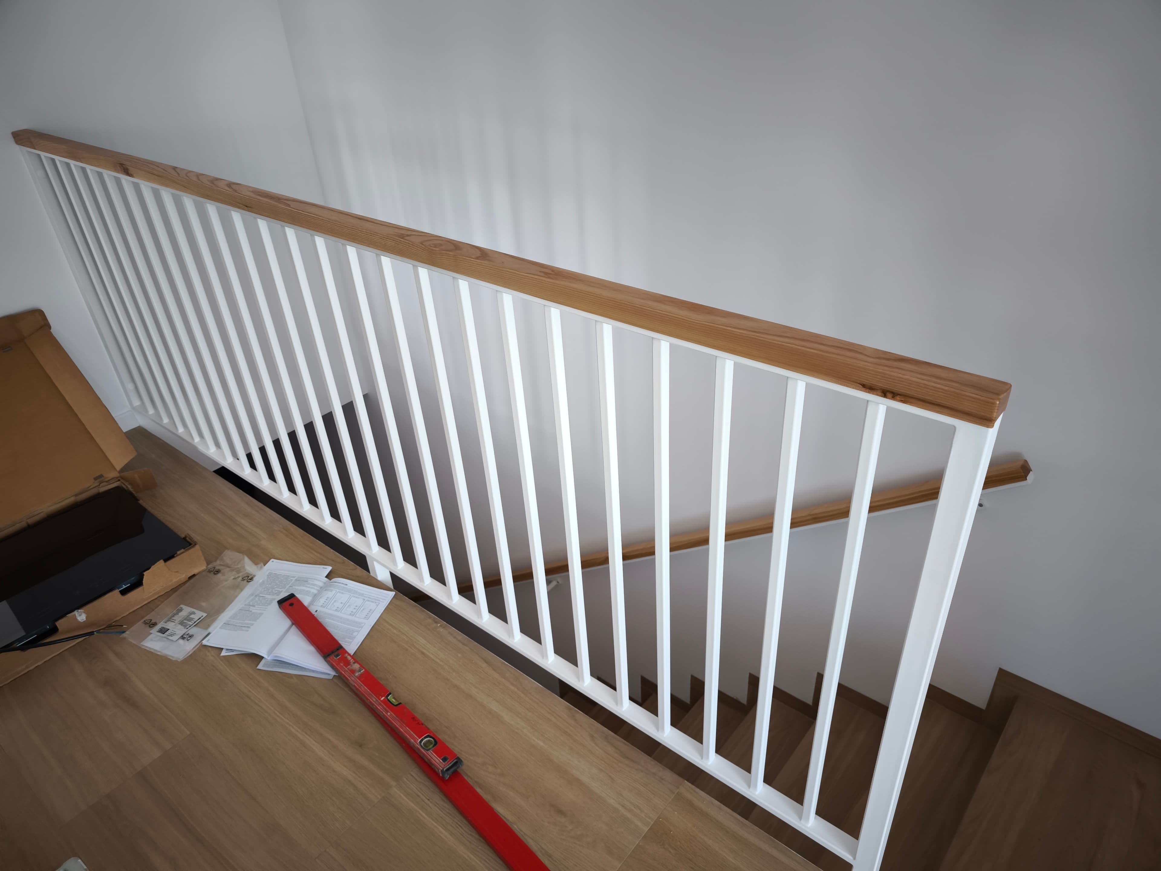 Biała balustrada schodowa z drewnianym pochwytem – wnętrze domu, FK-METAL Słupsk