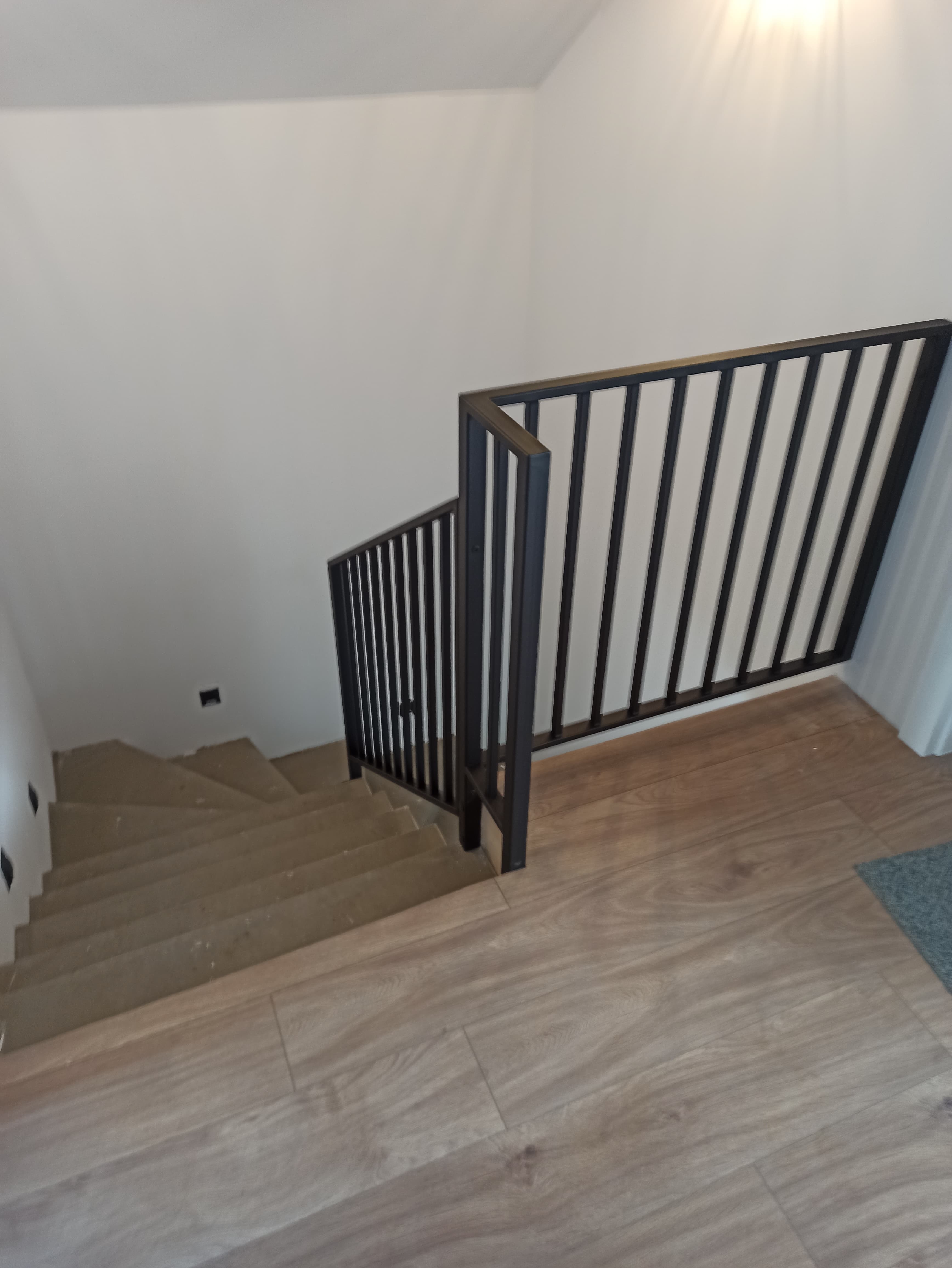 Czarna balustrada metalowa z pionowymi szczeblami na schody