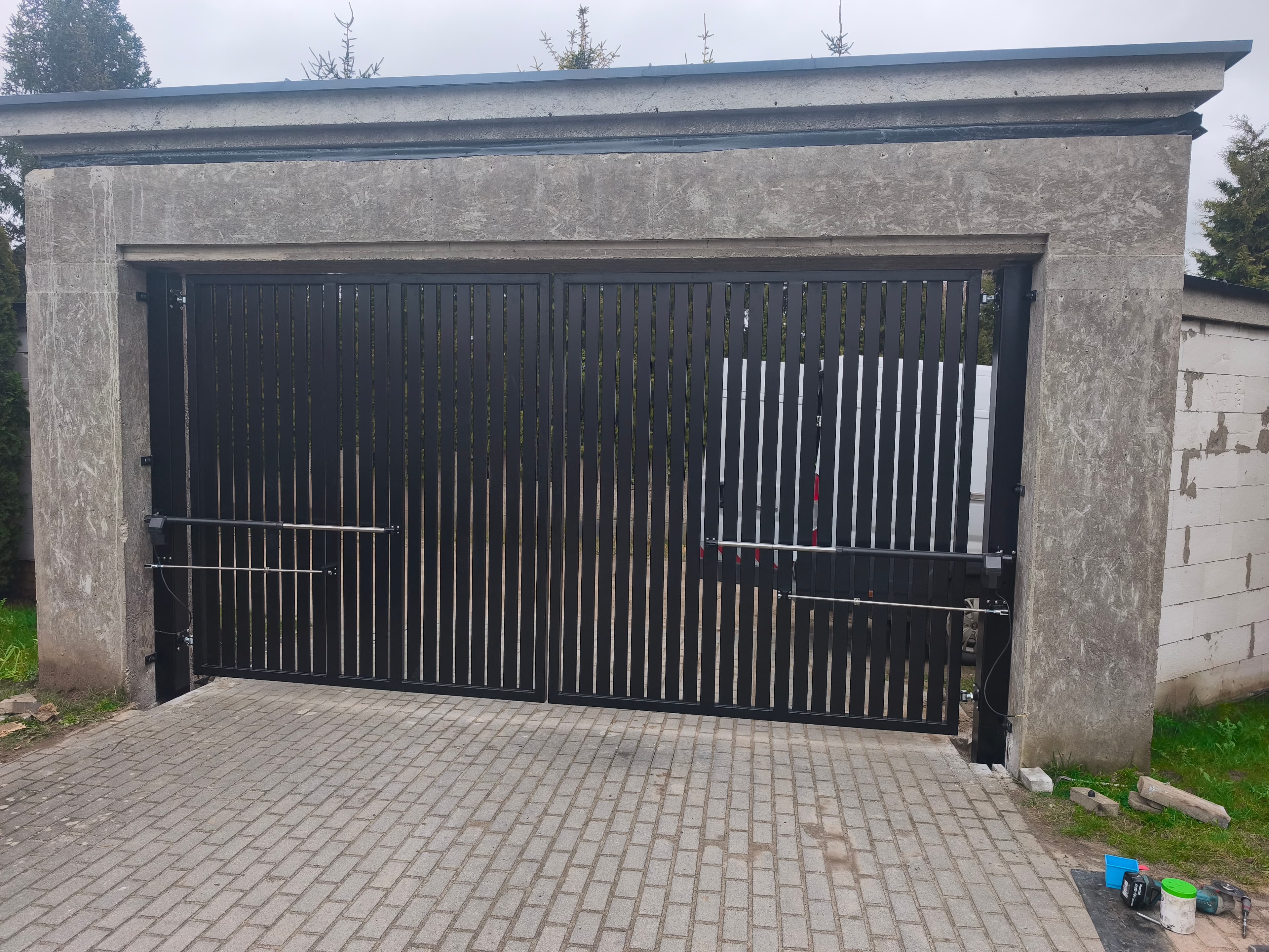 Czarna brama garażowa dwuskrzydłowa z pionowymi listwami – spawanie FK-METAL