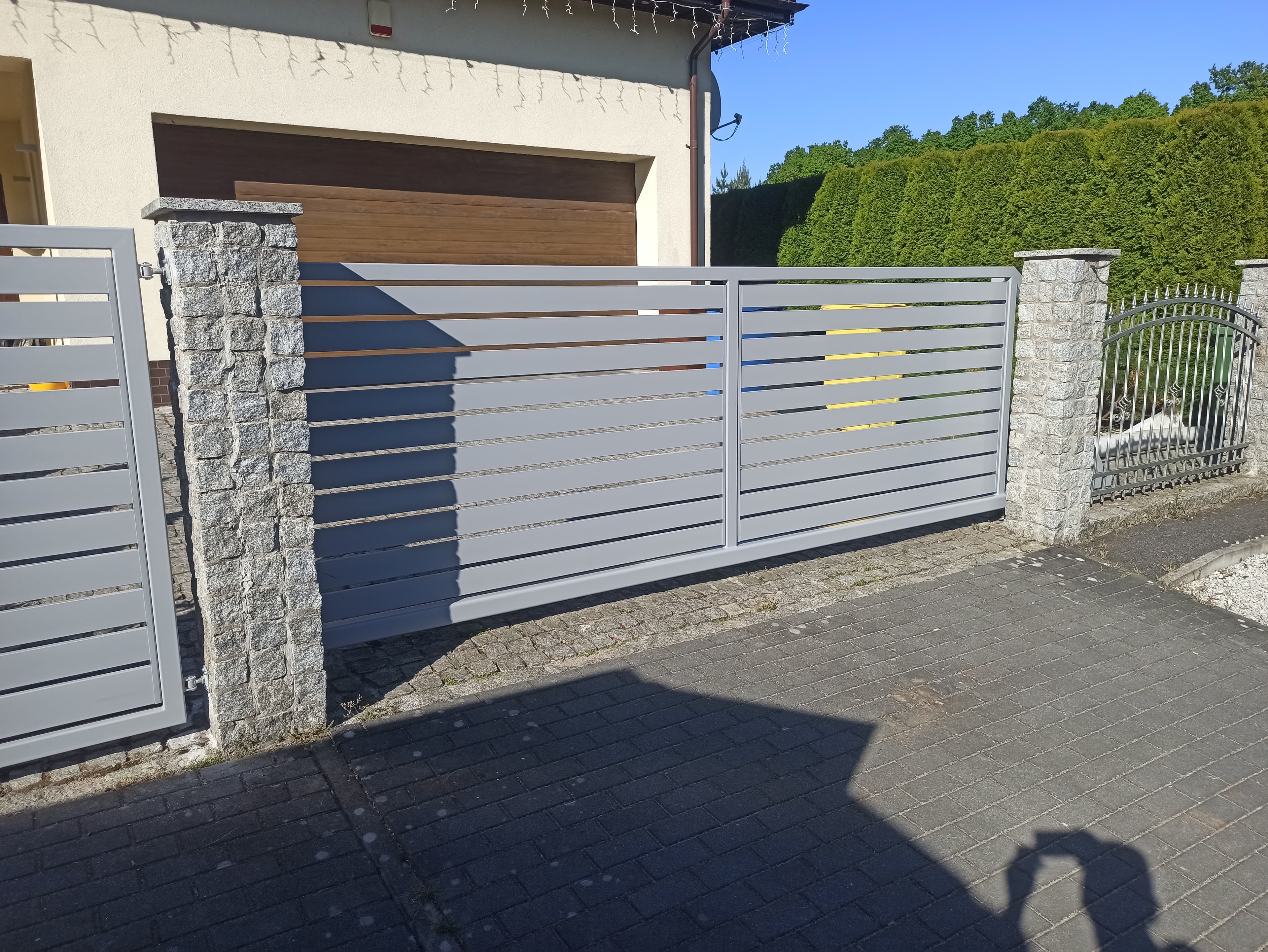 Brama wjazdowa z poziomymi lamelami szara z ogrodzeniem – realizacja Słupsk