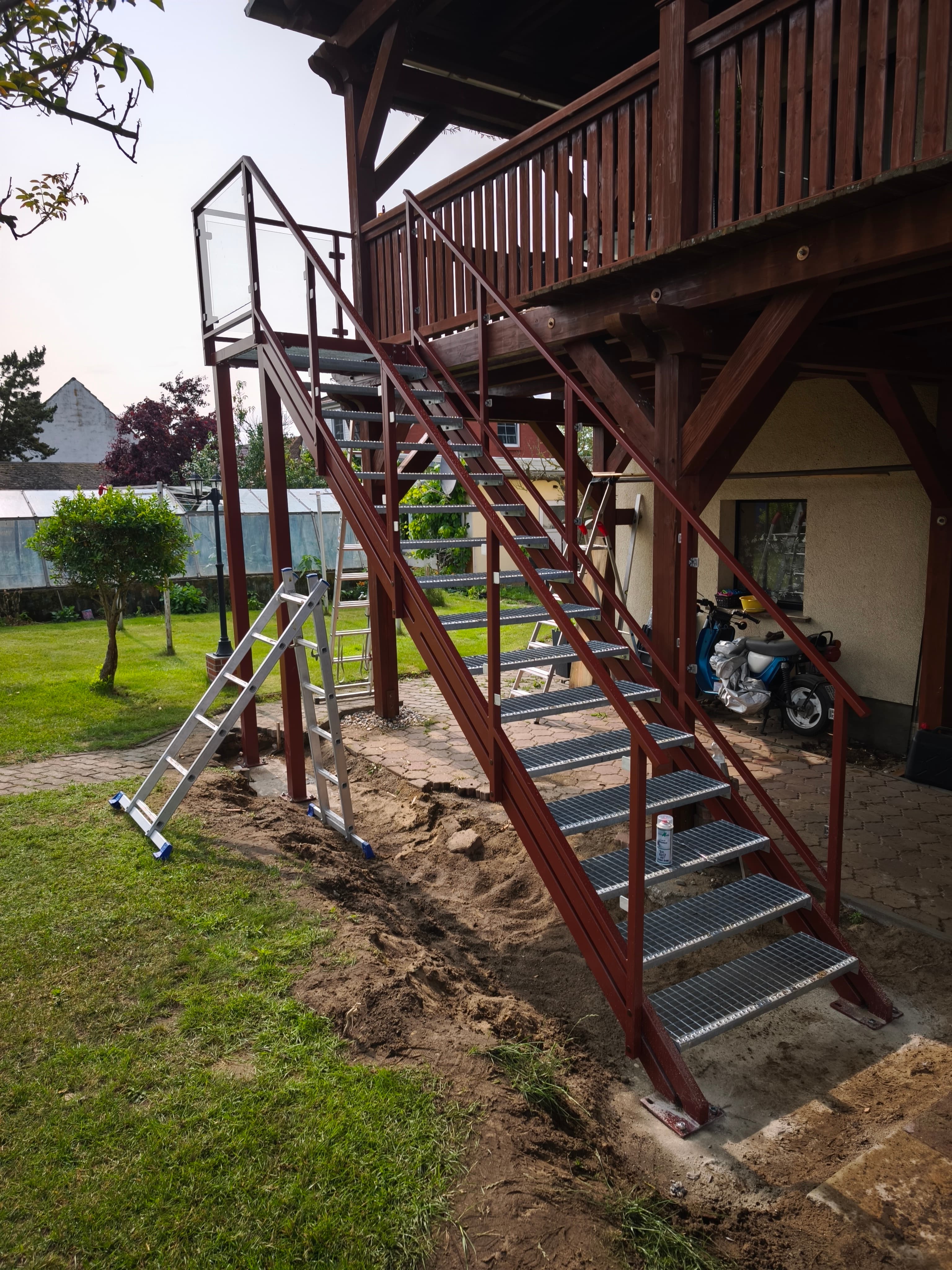 Schody zewnętrzne metalowe z balustradą szklaną – realizacja ogrodowa